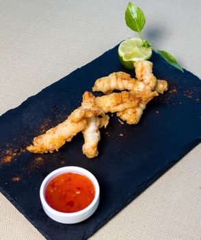 Chicken Ring, nugget, calamari with tomato sauce on the black plate