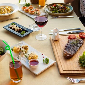 Tasty steak with vegetables on a wooden plate, garnish, juice