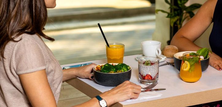 Two woman eating tasty chicken salads with dessert