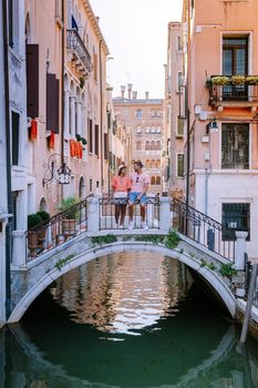 couple men and woman on a city trip to Venice Italy, colorful streets with canals Venice. Europe