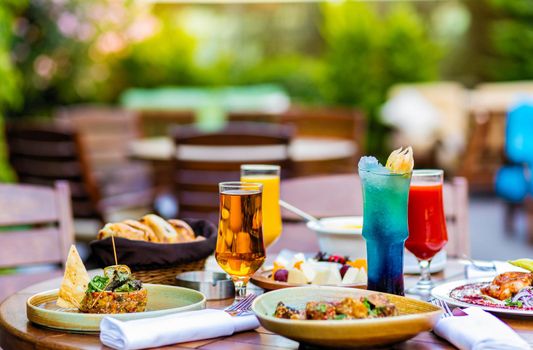 Tasty meals, cocktail, bread on the terrace restaurant table