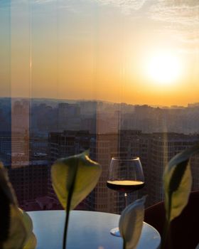 Red wine glass with city view, sunset view