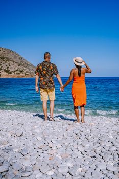 Crete Greece Plaka Lassithi with is traditional blue table and chairs and the beach in Crete Greece. Paralia Plakas, Plaka village Crete, couple on vacation holiday in Greece