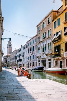 couple men and woman on a city trip to Venice Italy, colorful streets with canals Venice. Europe