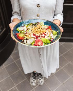 Woman holding salad outside