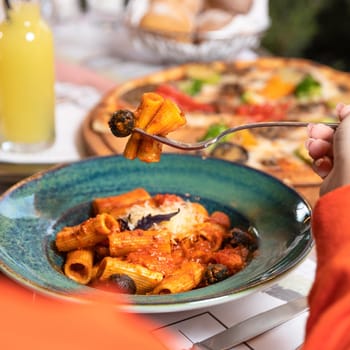 Eating pasta with red sauce close up