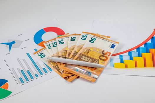 50 euro bills with statistics and a pen on a white background