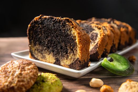 Sweet swiss roll roulette with caramel and cream and milk chocolate shards over it