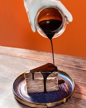 Pouring chocolate cream on the cake