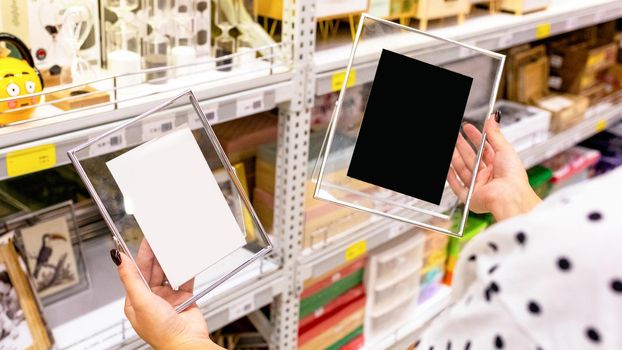 Woman holding transparent photo frames at the store
