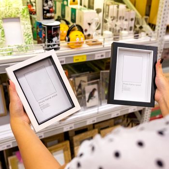 Woman holding black and white photo frames at the store