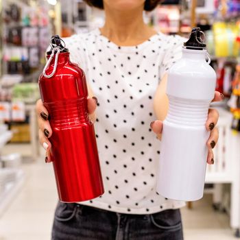 Woman holding red and white stainless steel water bottle