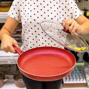 Woman holding red frying pan close up