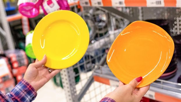 Woman holding a colorful kitchen plate at the store