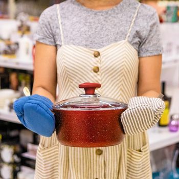 Woman holding a red frying pan