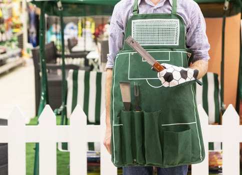 Gardener man holding a tool with green apron