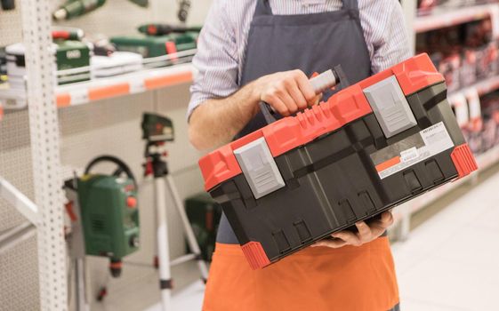 Man holding heavy duty plastic tool box at the store