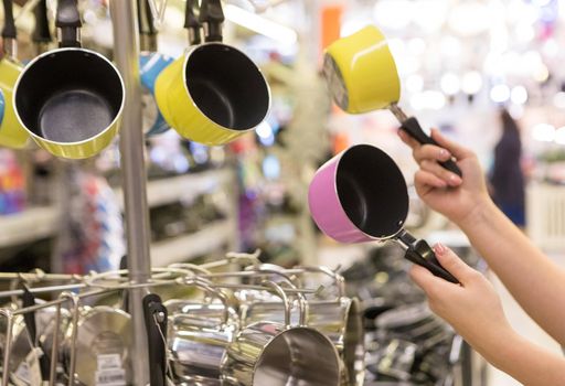 Woman holding colorful small pans at the store