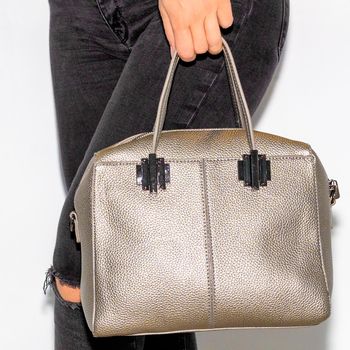 Woman holding brown leather handbag close-up