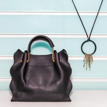 Black female bag with accessorize on a white background isolated