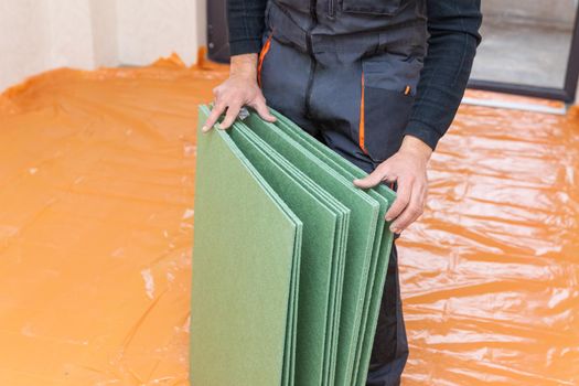 Man working with underlayment for flooring