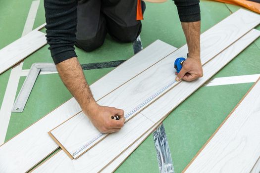 Worker measure length of the white wood laminate