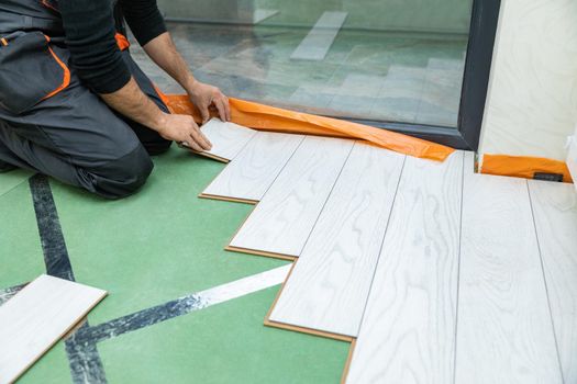 Man installing new laminated wooden floor