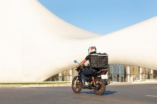 Courier worker driving a motorcycle in the city