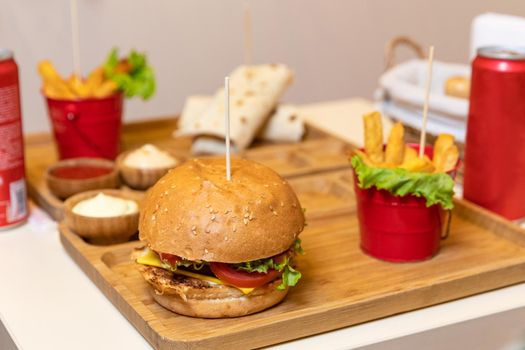 Tasty burger with french fries, ketchup and soda