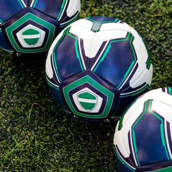 Football, soccer balls on the green grass