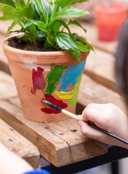 Children are painting potted plants made of pottery close up