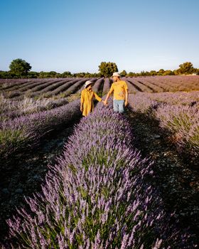 couple men and woman watching sunset in lavender fields in the south of France, Ardeche lavender fields iduring sunset, Lavender fields in Ardeche in southeast France.Europe