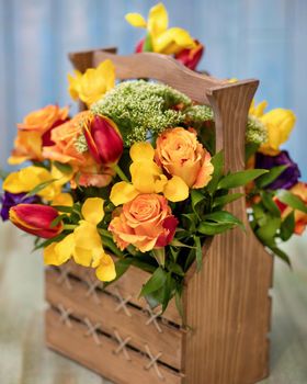Colorful flower bouquet in the wood box with blue background