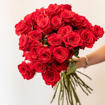 Woman holding beautiful flower bouquet, red rose