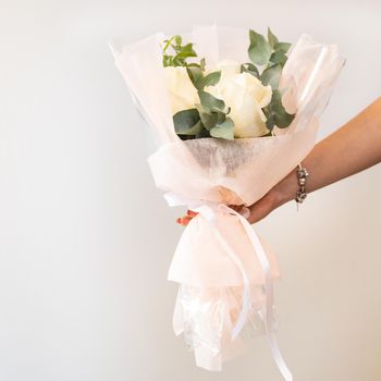 Woman holding white flower bouquet with white background