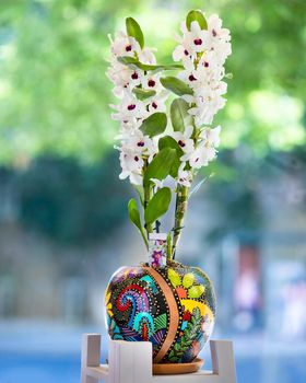 White Dendrobium nobile orchid flower in the painted pot