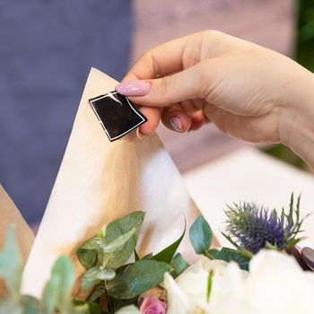 Florist Woman making of a flower bouquet and putting sticker, logo place