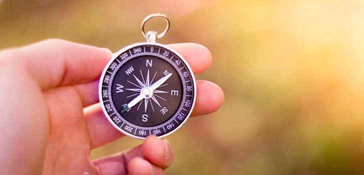 Vintage compass in man’s hand, adventure and discovery concept