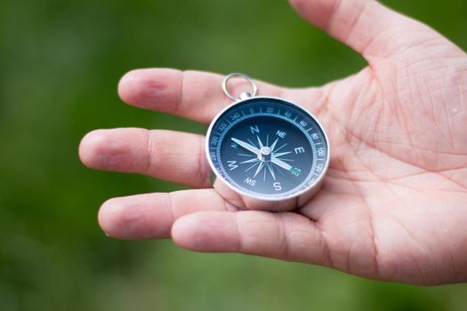 Vintage compass in man’s hand, adventure and discovery concept