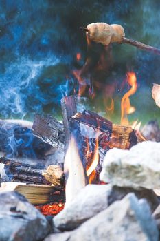 Having a barbecue on the bonfire, outdoors. Baking bread.