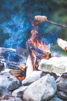 Having a barbecue on the bonfire, outdoors. Baking bread.