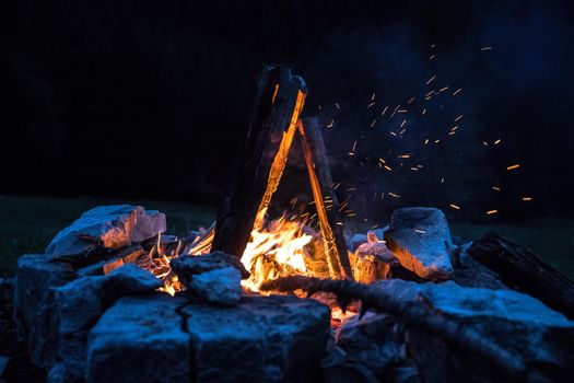 Forest bonfire in the summer, camping time with friends. Copy space.