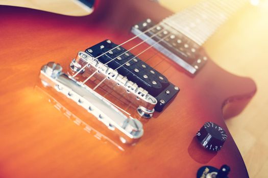 Electronic guitar in sunburst optic lying on the wooden floor