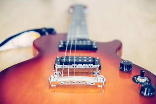 Electronic guitar in sunburst optic lying on the wooden floor