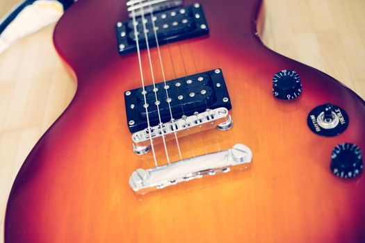 Electronic guitar in sunburst optic lying on the wooden floor