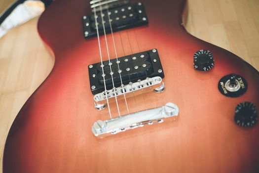 Electronic guitar in sunburst optic lying on the wooden floor