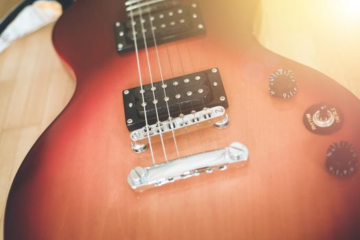 Electronic guitar in sunburst optic lying on the wooden floor