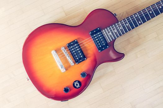 Electronic guitar in sunburst optic lying on the wooden floor