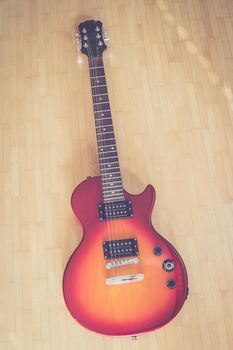 Electronic guitar in sunburst optic lying on the wooden floor