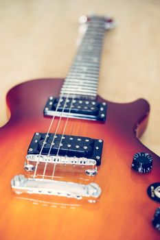 Electronic guitar in sunburst optic lying on the wooden floor